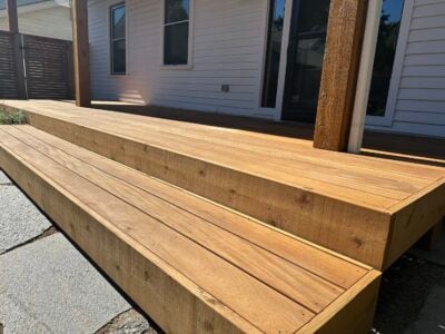 Premium hardwood decking featuring smooth, sanded boards with rich grain, ideal for high-quality outdoor spaces.