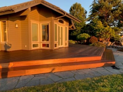 An ipe deck wrapping around a house during golden hour.