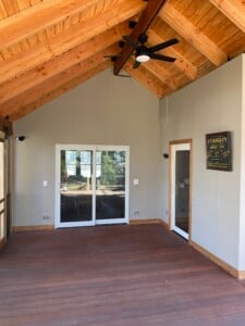 A covered batu deck leading into a house.