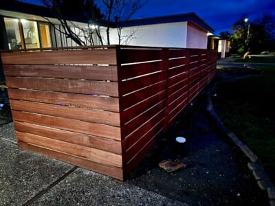 A South Pacific Redwood fence in front of a house at night