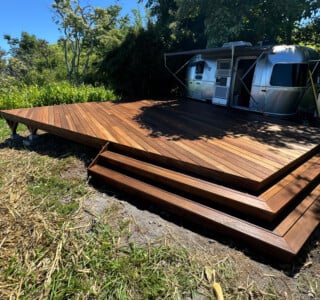 front view batu hardwood deck outside an airstream overlooking the water